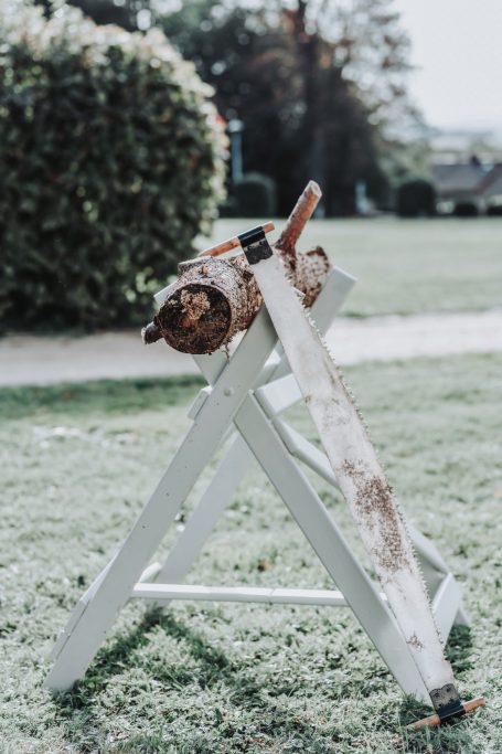 Holzscheit auf einem weißen Holzständer im Freien, umgeben von Gras.