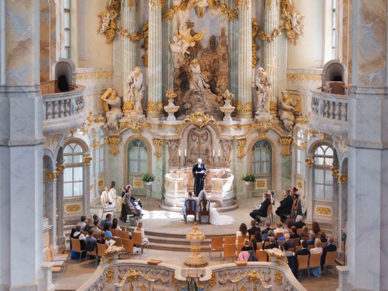 Ein prächtiger Kirchenraum mit einer sermoniellen Veranstaltung und versammeltem Publikum.