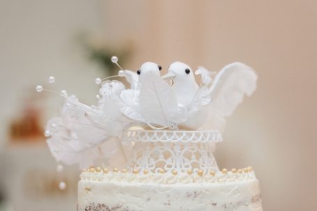 Dekorative Tauben und Blumen auf einer Hochzeitstorte.